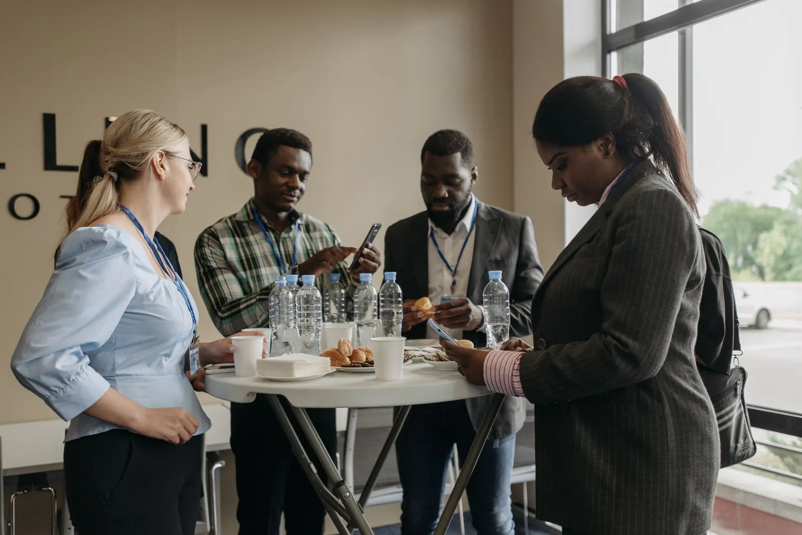 Illustrative stock photo: a diverse group of professionally dressed people talking in small groups at a networking event. Not a Friends of Abuja event.